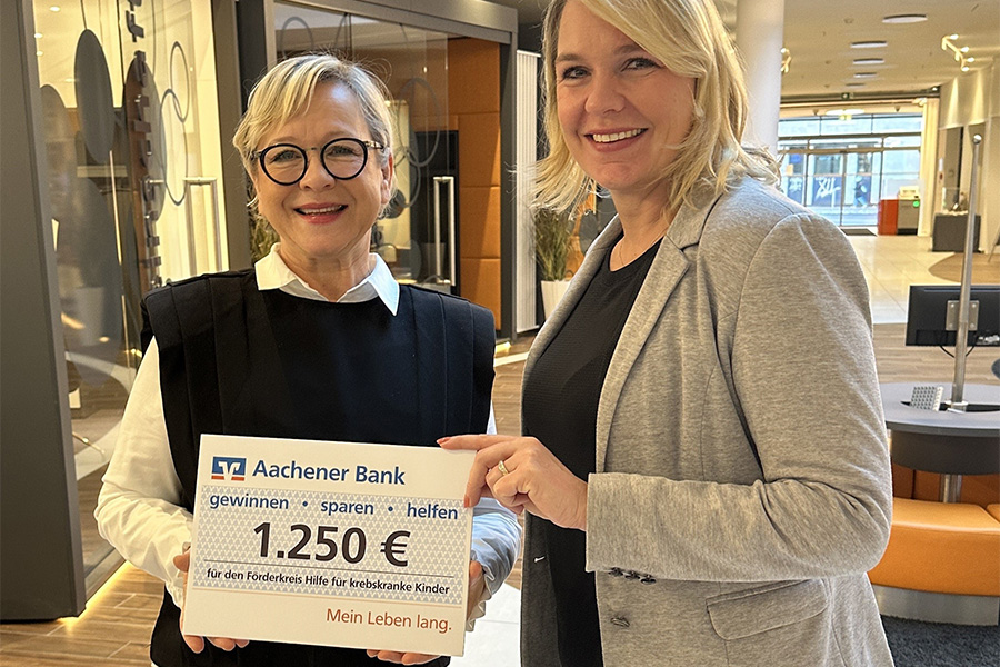 Eine Mitarbeiterin der Volksbank Aachen überreicht eine Spende an Frau Göschel, Vorsitzende des Vereins Förderkreis krebskranke Kinder e.V. Aachen